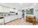 Cozy kitchen features white appliances, tile flooring, and adjacent dining area with backyard views at 6948 W Country Club N Dr, Sarasota, FL 34243