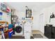 Well-organized laundry room with washer, dryer, storage shelving, and a utility sink at 6948 W Country Club N Dr, Sarasota, FL 34243