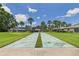 Enjoy a sunny day on the community shuffleboard court surrounded by lush landscaping and palm trees at 6948 W Country Club N Dr, Sarasota, FL 34243