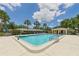 Beautiful community pool area featuring plenty of seating, palm trees, and a pool house at 6948 W Country Club N Dr, Sarasota, FL 34243