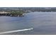 Aerial view of a large boat speeding across the water with waterfront homes nestled along the lush shoreline at 6948 W Country Club N Dr, Sarasota, FL 34243