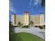 Spacious condominium with circular driveway, lush landscaping, and covered parking, set against a clear blue sky at 4750 Cove Cir # 502, St Petersburg, FL 33708