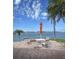 Waterfront patio area with a table, umbrella, four chairs, and gorgeous views on a sunny day at 4750 Cove Cir # 502, St Petersburg, FL 33708