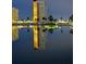 Striking view of the building reflected in the pond with palm trees, a bridge and moody lighting at 4750 Cove Cir # 502, St Petersburg, FL 33708