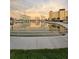 Reflective pond view of the property, with lush green landscaping and concrete walking path at 4750 Cove Cir # 502, St Petersburg, FL 33708