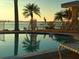 Relaxing poolside view of the water with palm trees reflecting in the clear water at this waterfront property at 4750 Cove Cir # 502, St Petersburg, FL 33708