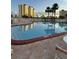 Inviting outdoor pool area with lounge seating, surrounded by well-maintained landscaping and clear blue skies at 4750 Cove Cir # 502, St Petersburg, FL 33708