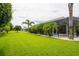 Large backyard with manicured lawn and screened-in pool, perfect for relaxing and entertaining at 14041 Bassingthorpe Dr, Spring Hill, FL 34609