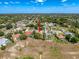 Aerial view of a home in a lush, green neighborhood featuring swimming pools and mature trees at 1052 Archway Dr, Spring Hill, FL 34608