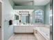 Modern bathroom with double vanity, soaking tub, and large mirror with stylish lighting at 1052 Archway Dr, Spring Hill, FL 34608