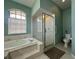 Elegant bathroom featuring a soaking tub, glass-enclosed shower, and stylish tile accents at 1052 Archway Dr, Spring Hill, FL 34608