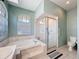 Bathroom with soaking tub, walk-in shower and arched window at 1052 Archway Dr, Spring Hill, FL 34608