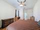 Primary bedroom featuring wood floors, ceiling fan, dresser, and bathroom access at 1052 Archway Dr, Spring Hill, FL 34608