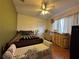 Comfortable bedroom featuring laminate flooring, a ceiling fan, and a floral-patterned bench at 1052 Archway Dr, Spring Hill, FL 34608