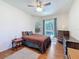 Comfortable bedroom with a bed, dresser, ceiling fan, and sliding glass door to an outdoor area at 1052 Archway Dr, Spring Hill, FL 34608