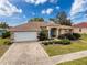 Beautiful one-story home featuring a manicured lawn, paved driveway, and an attached two-car garage at 1052 Archway Dr, Spring Hill, FL 34608