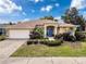 Charming home featuring a well-manicured front yard, a two-car garage, and a welcoming entrance at 1052 Archway Dr, Spring Hill, FL 34608