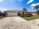 Charming single-story home with a brick-paved driveway and well-maintained landscaping under a sunny blue sky at 1052 Archway Dr, Spring Hill, FL 34608