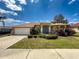Charming home with a well-manicured lawn, a two-car garage, and a welcoming front entrance at 1052 Archway Dr, Spring Hill, FL 34608