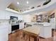 Well-lit kitchen with stainless steel appliances, white cabinetry, and terracotta tile flooring at 1052 Archway Dr, Spring Hill, FL 34608