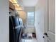 Laundry room with modern appliances, white floors and small window at 1052 Archway Dr, Spring Hill, FL 34608