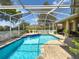 Inviting screened-in pool with brick surround and white fence, perfect for relaxing and entertaining at 1052 Archway Dr, Spring Hill, FL 34608