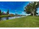 Scenic backyard with a picturesque canal view, lush green lawn, and mature trees at 536 Boundary Blvd, Rotonda West, FL 33947
