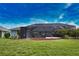 Landscaped backyard featuring a screened-in lanai, mature trees, and a well-maintained lawn at 536 Boundary Blvd, Rotonda West, FL 33947