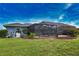 Well-maintained backyard with a screened-in lanai, lush lawn, and privacy landscaping at 536 Boundary Blvd, Rotonda West, FL 33947