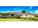 Charming one-story home with manicured lawn and a 2-car garage, framed by lush landscaping under a bright blue sky at 536 Boundary Blvd, Rotonda West, FL 33947