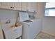 Convenient laundry room with washer, dryer, utility sink, and ample cabinet space at 536 Boundary Blvd, Rotonda West, FL 33947