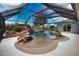 Inviting screened-in pool area featuring a rock waterfall, spa, and ample lounging space, creating a backyard oasis at 536 Boundary Blvd, Rotonda West, FL 33947