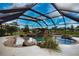 Spectacular screened-in lanai and custom pool with waterfall feature and lush landscaping at 536 Boundary Blvd, Rotonda West, FL 33947