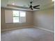 Bright bedroom features a ceiling fan, neutral carpeting, and a window with plantation shutters at 13639 Salinas St, Venice, FL 34293