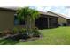 Exterior home view featuring a covered lanai and landscaped yard with palm trees at 13639 Salinas St, Venice, FL 34293
