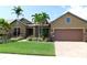 Charming single-story home showcasing lush landscaping, a well-manicured lawn, and a two-car garage at 13639 Salinas St, Venice, FL 34293