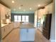Bright and airy kitchen with stainless appliances, center island and sliding doors to back at 13639 Salinas St, Venice, FL 34293