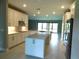 Modern kitchen with stainless steel appliances, quartz counters, island, and eat-in area at 13639 Salinas St, Venice, FL 34293