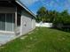 The backyard offers a lush lawn and partial view of the property, enclosed by a white fence at 21970 Cellini Ave, Port Charlotte, FL 33952