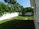 The spacious backyard features a well-maintained lawn and a tall white fence for privacy at 21970 Cellini Ave, Port Charlotte, FL 33952