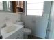 Cozy bathroom featuring a single sink vanity, toilet, and window at 21970 Cellini Ave, Port Charlotte, FL 33952