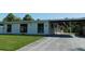 Charming single-story home featuring a covered parking area and well-maintained front lawn at 21970 Cellini Ave, Port Charlotte, FL 33952