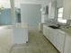 Bright kitchen with white cabinets, stylish backsplash, stone countertops, and open to the living area at 21970 Cellini Ave, Port Charlotte, FL 33952