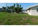 Expansive backyard with lush greenery, mature palm trees, and a screened in gazebo at 3536 Harbor Blvd, Port Charlotte, FL 33952