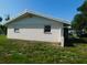 Side view of home featuring a white exterior with grassy yard at 3536 Harbor Blvd, Port Charlotte, FL 33952