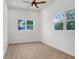 An empty bedroom with plank flooring, white walls, a ceiling fan and two windows allowing natural sunlight at 14 S Forest St, Plant City, FL 33563