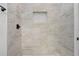 Shower featuring neutral toned marble-patterned tiles and a contrasting white mosaic niche at 14 S Forest St, Plant City, FL 33563