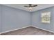 Serene bedroom with gray walls, wood-look floors and ceiling fan at 6110 Downing St, Dover, FL 33527