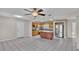Open kitchen features a granite island, stainless steel appliances, and wood cabinets at 6110 Downing St, Dover, FL 33527
