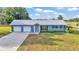 Ranch-style home with metal roof, two-car garage, and landscaped yard at 6110 Downing St, Dover, FL 33527